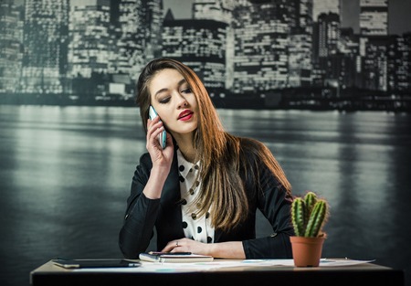 A studio shot of a beautiful woman works in economical sphere. Successfully young brunette smiling...