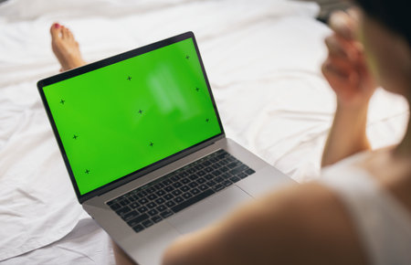 Woman with green screen laptopの写真素材