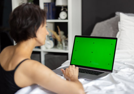Woman with green screen laptopの写真素材