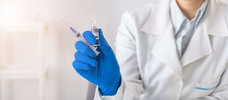 Doctor holding vaccine and syringe