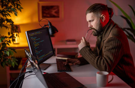 Thoughtful man coding on pc