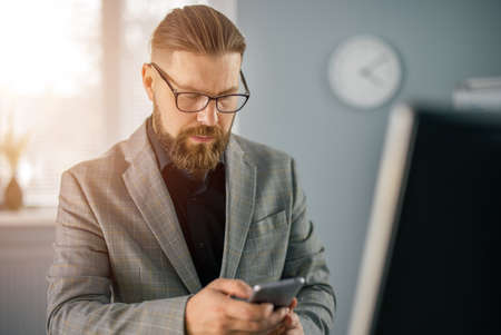 Businessman using smartphone at officeの写真素材