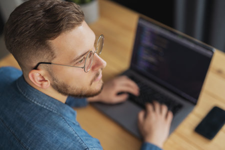 Man writing code on laptop