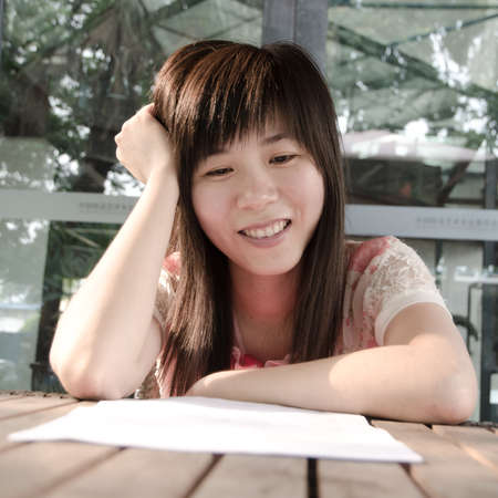 asian woman on desk with paper outdoorの写真素材
