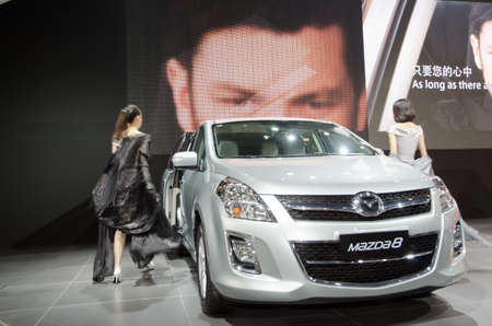 GUANGZHOU, CHINA - NOV 26: unidentified model with Mazda 8 car at the 9th China international automobile exhibition. on November 26, 2011 in Guangzhou China.のeditorial素材