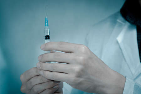 asian men doctor with medical syringe in handの写真素材