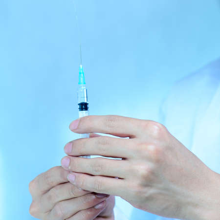 asian men doctor with medical syringe in handの写真素材