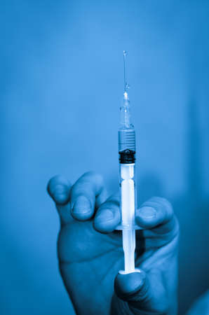asian men doctor with medical syringe in handの写真素材