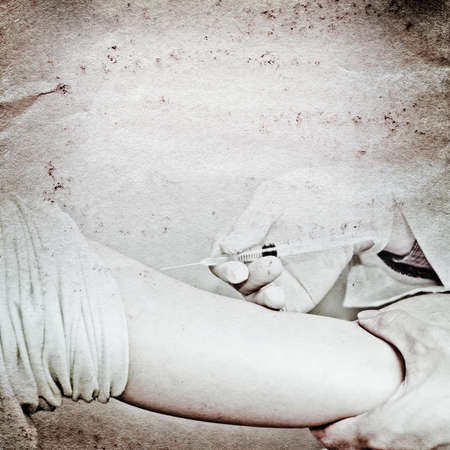 doctor injecting vaccination with patient hand old grunge paper texture backgroundの写真素材