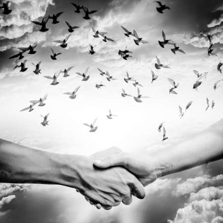 hand shake with dove flying on sky, business concept background.の写真素材