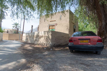 RUSTAQ, OMAN - OCTOBER 26, 2018: Pink car near a small house in the shade of a tree in the oasis near Rustaq Fortのeditorial素材