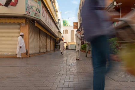 Dubai, United Arab Emirates - December 2, 2018:Pakistani men walking and waiting in a street of the popular and ethnic Deira district in Dubaiのeditorial素材