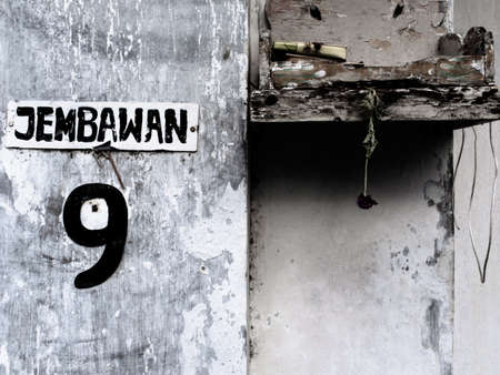 Ubud, Bali, Indonesia - September 19, Close-up on a street number "nine" and a faded temple offeringのeditorial素材