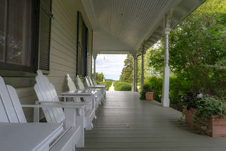 Metis-sur-Mer, Quebec, Canada - August 23, 2018: Front house veranda of the Estevan Lodge, with adirondack chairs, Reford gardens, Metis-sur-mer, Quebecのeditorial素材