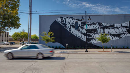 Sacramento, California, United States - September 8, 2018: Street mural painted mostly in black and white showing a woman head with a grey car passing by with motion blur in Sacramento, Californiaのeditorial素材