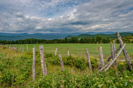 Fields in the hilly landscape of Charlevoix with wooden fencing in the foreground, Province of Quebec, Canadaの写真素材