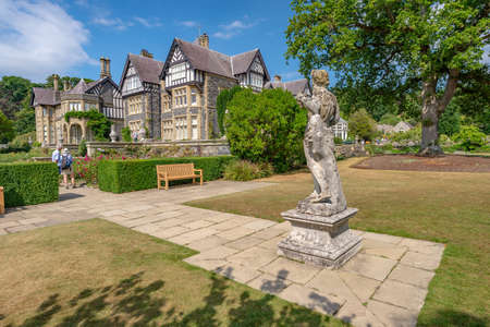 Bodnant Garden, Conwy, Wales, United Kingdom - July 19, 2018: Classical statue looking towards Bodnant Hall and two visitors, Bodnant garden, Conwyのeditorial素材