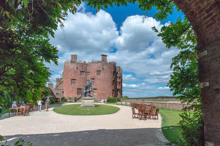 Powis Castle, Powys, Wales, United Kingdom - July 22, 2018: Sculpture and red brick tower viewed through the entrance gate, Powis Castle, Powys, Walesのeditorial素材