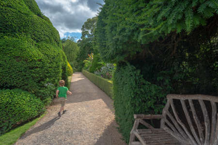 Powis Castle, Powys, Wales, United Kingdom - July 22, 2018: Young boy visiting the garden, Powis Castle, Powys, Walesのeditorial素材