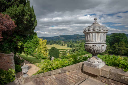 Powis Castle, Powys, Wales, United Kingdom - July 22, 2018: Bronze urn and view on the park and the surrounding landscape, Powis Castle, Powys, Walesのeditorial素材