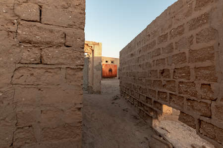 RAS AL KHAIMAH, UNITED ARAB EMIRATES - MARCH 8, 2019: A red dominance photograph at the end of a perspective in the abandoned village of Al Jazirah Al Hamra at sunset, Emirate of Ras Al Khaimahのeditorial素材