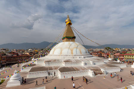 Bauddha, Nepal - April 1, 2019: Budhanath stupa seen on an partly overcast spring afternoon from one of restaurant terrace located at the edge of the square in which it standsのeditorial素材