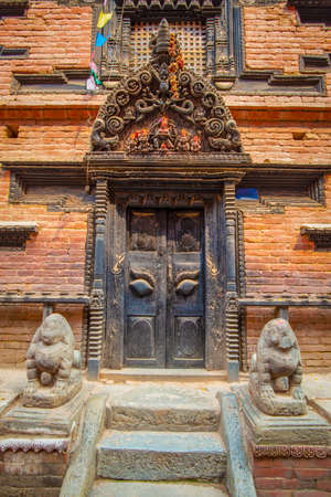 Old ornamented newari style door taken during a sunny afternoon in the historical center of Bhaktapur, Nepalの写真素材
