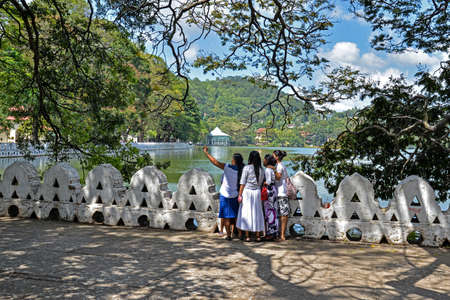 Kandy, Sri Lanka - July 6, 2016:  Framed view of a group of women taking a selfie on Kandy Lake shoreのeditorial素材