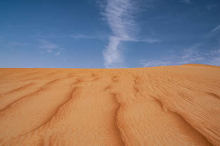Red sand dunes with partly overcast sky,  with no foot steps taken on a late winter afternoon,...
