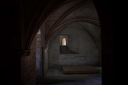 Tarascon, France - Nov 30, 2019: One small window seen from a dark interior of the Tarascon Castle wit vaulted ceilingsのeditorial素材