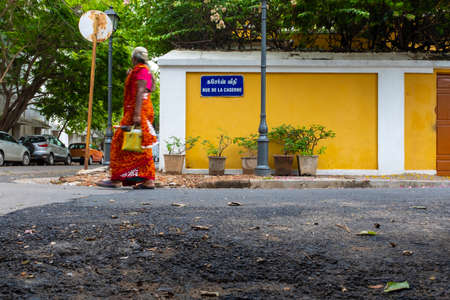 Pondicherry, India - March 19, 2018: Unrecognisable woman wearing bright colours is walking by a...