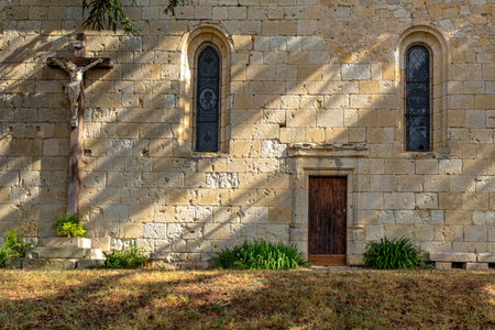 Side entrance and crucifix of the Notre-dame-du Rosaire church, taken on a sunny day with no people, located in Marsolan, Franceの写真素材
