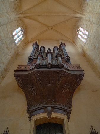 Low angle view of wooden large organ located in a plain, well lit gothic church in South West France with no peopleの写真素材