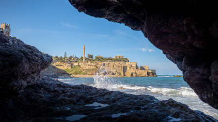 Vecchia Tonnara and Castello Tafuri at Portopalo di Capo Passero, Sicily, seen from a cave near the sea shore on a sunny winter day with no people.の写真素材