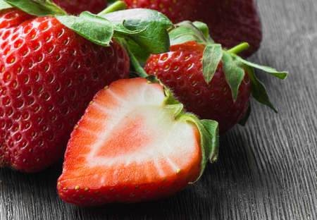 strawberries ripe, red, whole, half, close-up on a dark backgroundの写真素材