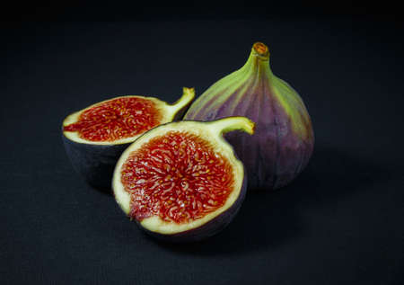 figs, whole and half on green wooden backgroundの写真素材