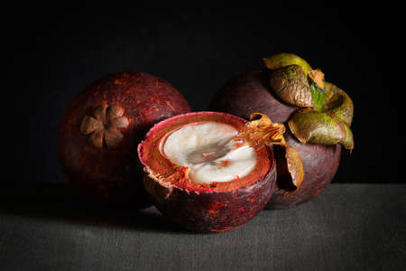 mangosteen fruit, half, whole on dark wooden backgroundの写真素材