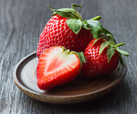 strawberries ripe, red, whole, half, close-up on a dark backgroundの写真素材