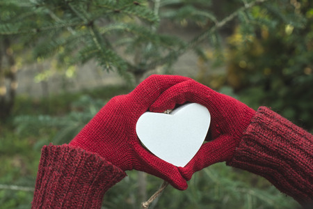 Hands in gloves and white heart shapeの写真素材
