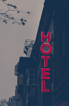 Small cheap hotel. Text Hotel on facade. Hotel in the city.の写真素材