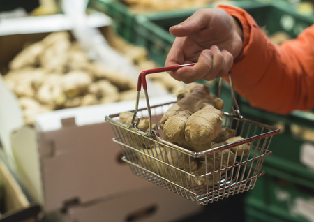 Fruits in supermarket. Buying kiwi in shop. Small basket.の写真素材