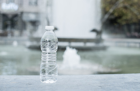 Bottle mineral water and fountain on the background