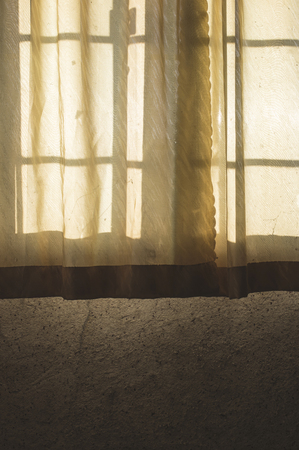 An old curtain on a window. Sunlightの写真素材