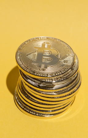 Bitcoin stack on yellow backgroundの写真素材