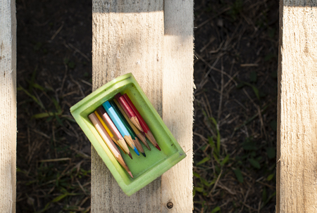 Small pencils in a box and booksの写真素材