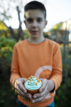 Boy holding blue color muffin. Close upの写真素材