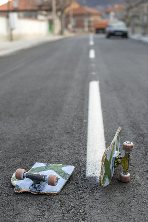 Broken skateboard on dark asphalt street. White street line.の写真素材