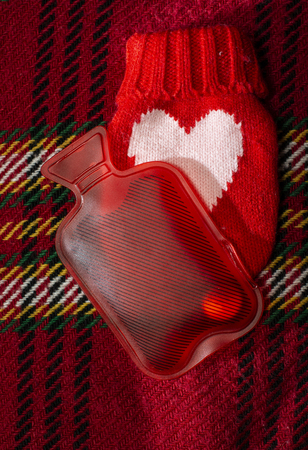 Red Hot Water Filling Bag  for warming placed on winter woolen carved blanket. Cold in the winter...