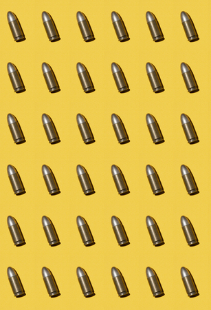 Background of various weapon repeated cartridges ammunitions on stone dark base. Military conflict concept.の写真素材