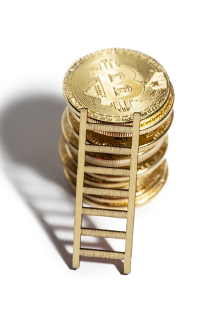 Many bitcoin coins stacked and leaned ladder. White isolated bitcoins. Concept for cryptocurrencies and investments.の写真素材